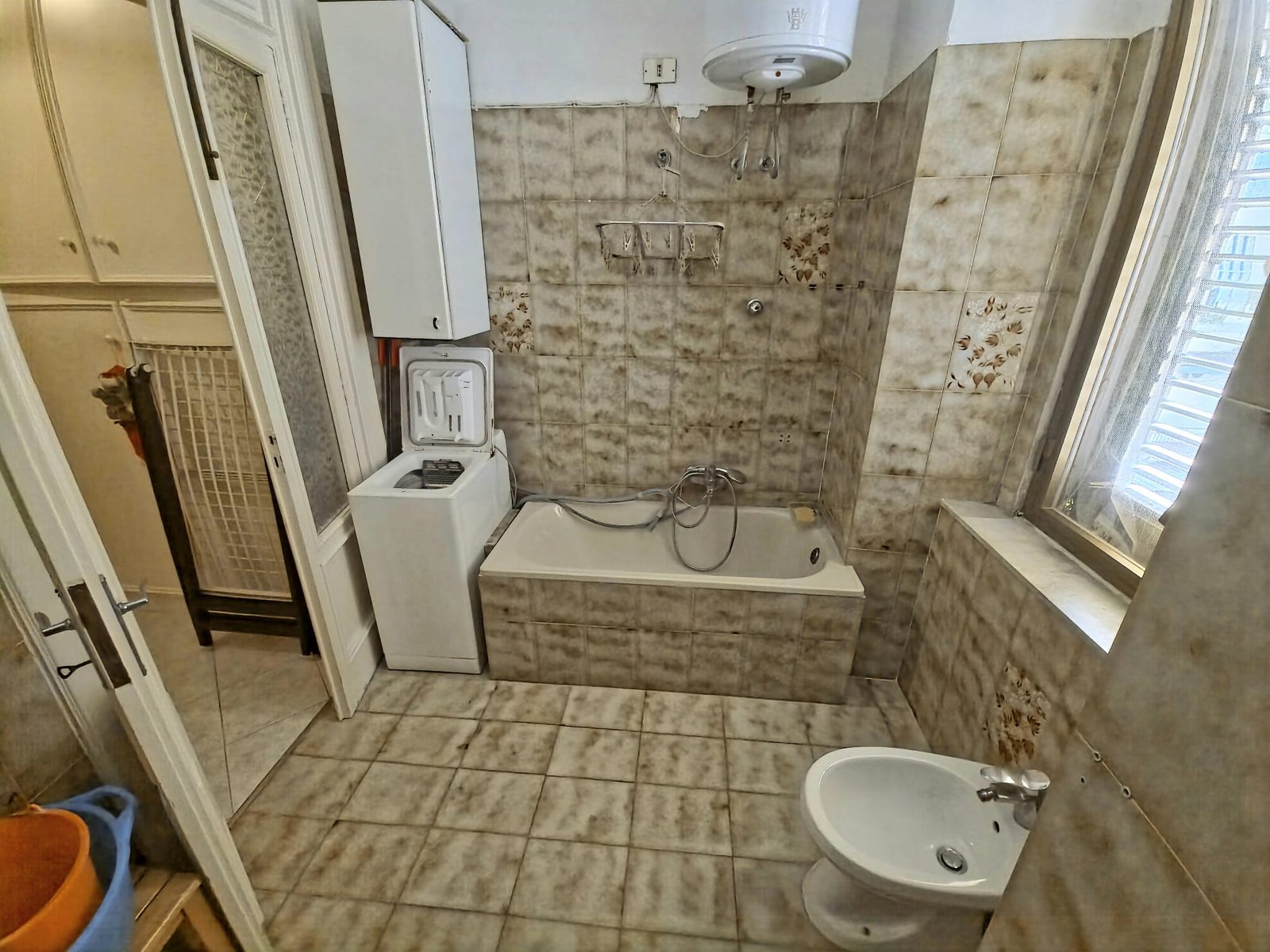 Bagno con vasca, lavatrice e finestra